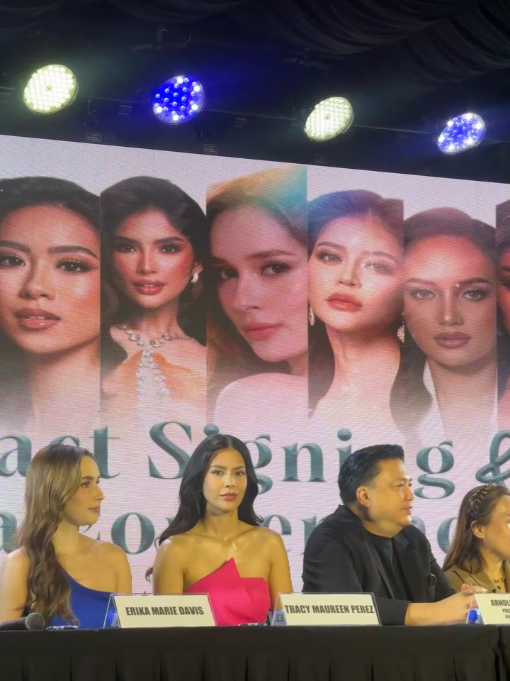 Tracy Maureen Perez walking the stage at a media event wearing a pink dress